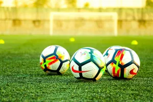three white-and-black soccer balls on field jigsaw puzzle