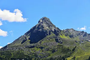 Stunning view of a mountain peak with rocky terrain under a clear blue sky, perfect for travel and nature enthusiasts. jigsaw puzzle