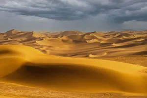 Vast sand dunes under dramatic storm clouds in a remote desert scene. jigsaw puzzle