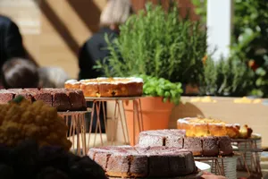 Assorted cakes displayed on tables outdoors in Milan, perfect for a sweet gathering. jigsaw puzzle