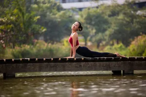 A woman enjoys a yoga pose on a bridge, showcasing flexibility and relaxation in a natural setting. jigsaw puzzle