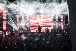 Energetic live music concert featuring performers on a vibrant stage, captivating a large audience. jigsaw puzzle