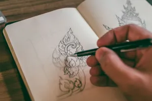 Close-up of a hand sketching detailed design in a sketchbook with mechanical pencil. jigsaw puzzle