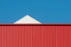 A minimalist photo of a red and white building against a clear blue sky. jigsaw puzzle