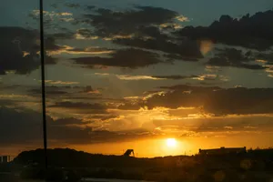 The sun is setting in the sky over a field jigsaw puzzle