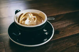 white and black ceramic mug filled with brown latte on round black ceramic saucer jigsaw puzzle