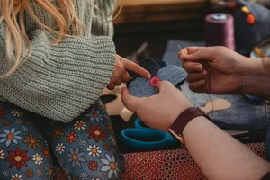 Hands crafting a denim patch with needle and thread. jigsaw puzzle