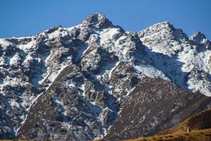 Breathtaking view of rugged, snow-covered mountains under a clear blue sky. jigsaw puzzle