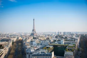 A stunning aerial view of Paris with the iconic Eiffel Tower and cityscape under a clear blue sky. jigsaw puzzle