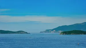 A vibrant and tranquil coastal view showcasing distant islands under a clear blue sky. jigsaw puzzle