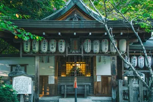 Serene view of a Japanese shrine adorned with lanterns amidst lush greenery. jigsaw puzzle
