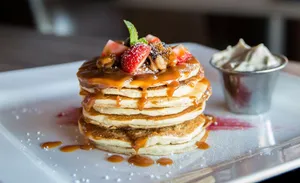 Mouthwatering pancakes with strawberries, nuts, and syrup on a plate. jigsaw puzzle