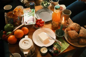 A cozy breakfast spread featuring fresh fruits, bread, and juice, surrounded by warm candlelight. jigsaw puzzle