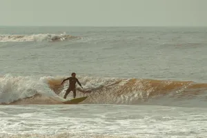 A surfer rides dynamic waves showcasing skill and balance in a thrilling ocean scene. jigsaw puzzle