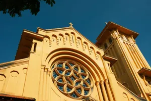Striking image of a yellow Catholic church facade against blue sky in Hanoi, Vietnam. jigsaw puzzle