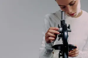 A scientist carefully examining samples using a microscope in a modern laboratory setting. jigsaw puzzle