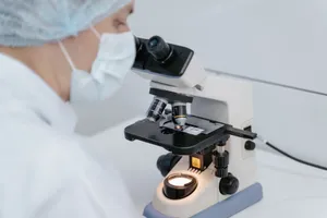 Scientist using a microscope in a laboratory setting, wearing protective gear. jigsaw puzzle