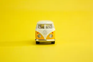 Classic Volkswagen bus scale model with a vibrant yellow backdrop, embodying retro charm. jigsaw puzzle