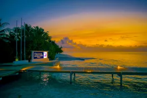 Golden hour view of a wooden deck by the sea in Maldives, with stunning sunset colors. jigsaw puzzle