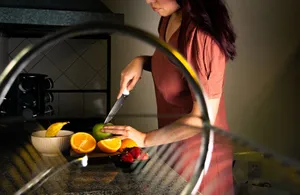 A woman slices fruits on the kitchen counter, showcasing a healthy lifestyle. jigsaw puzzle