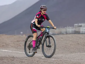 Female cyclist mountain biking on a rugged outdoor trail with scenic views. jigsaw puzzle