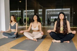 Three women practicing meditation in a yoga class indoors, promoting a calm and healthy lifestyle. jigsaw puzzle