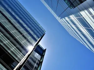 Low angle view of glass skyscrapers reflecting the bright sun in a clear blue sky. jigsaw puzzle
