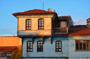 Charming rustic building with balconies and vibrant facade in an urban setting at sunset. jigsaw puzzle