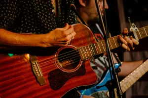 Hands playing an acoustic guitar during a live music performance in Boston. jigsaw puzzle