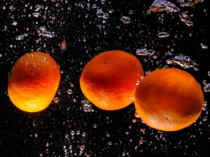 Fresh tangerines splashing underwater with bubbles highlighting their vibrant color and texture. jigsaw puzzle