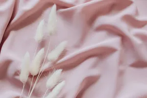 Soft white hare's tail grass on a flowing pink fabric backdrop creates a serene and gentle aesthetic. jigsaw puzzle