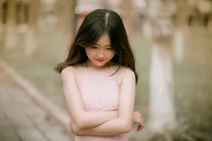 Portrait of a young woman with long hair in a pink lace dress, outdoors in a serene setting. jigsaw puzzle