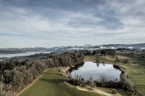 a view of a golf course with a lake and mountains in the background jigsaw puzzle