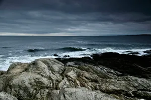 a large body of water sitting next to a rocky shore jigsaw puzzle