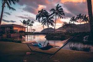 person on brown hammock with steel base across body of water jigsaw puzzle