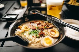 a bowl of ramen with chopsticks and a glass of beer jigsaw puzzle