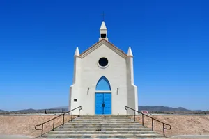 White chapel with blue doors under clear blue sky jigsaw puzzle