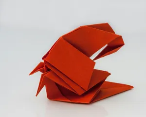a red origami bird sitting on top of a table jigsaw puzzle