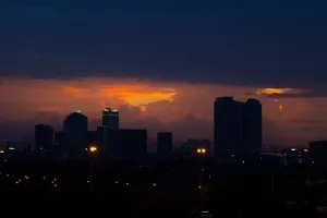 A city skyline silhouetted against a vibrant sunset, creating a dramatic urban scene. jigsaw puzzle