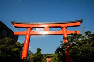 Breathtaking view of a traditional red Torii gate under blue skies in Kyoto, Japan. jigsaw puzzle