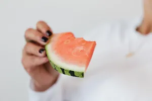 Bitten slice of fresh sweet juicy watermelon in hand of crop faceless female in white sweater jigsaw puzzle