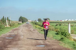 A man jogs on a rural dirt road, enjoying a sunny day in the countryside. jigsaw puzzle