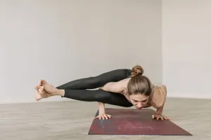 Woman performing a complex yoga pose on a mat indoors, showcasing strength and flexibility. jigsaw puzzle