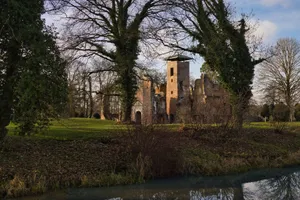A picturesque view of a historic castle ruin surrounded by nature on a clear day. jigsaw puzzle