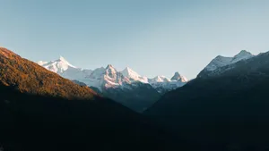 Snow-capped mountains bathed in golden sunlight jigsaw puzzle
