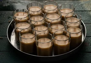 A metal tray filled with glasses filled with liquid jigsaw puzzle