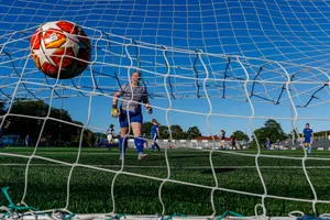 man in blue and white stripe shirt holding red and blue soccer ball jigsaw puzzle
