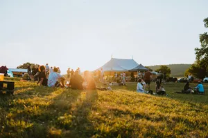 a group of people sitting on top of a lush green field jigsaw puzzle