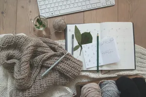 black pencil on white card beside brown knit textile jigsaw puzzle