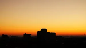 Silhouette of city buildings against a vivid orange sunrise sky. jigsaw puzzle